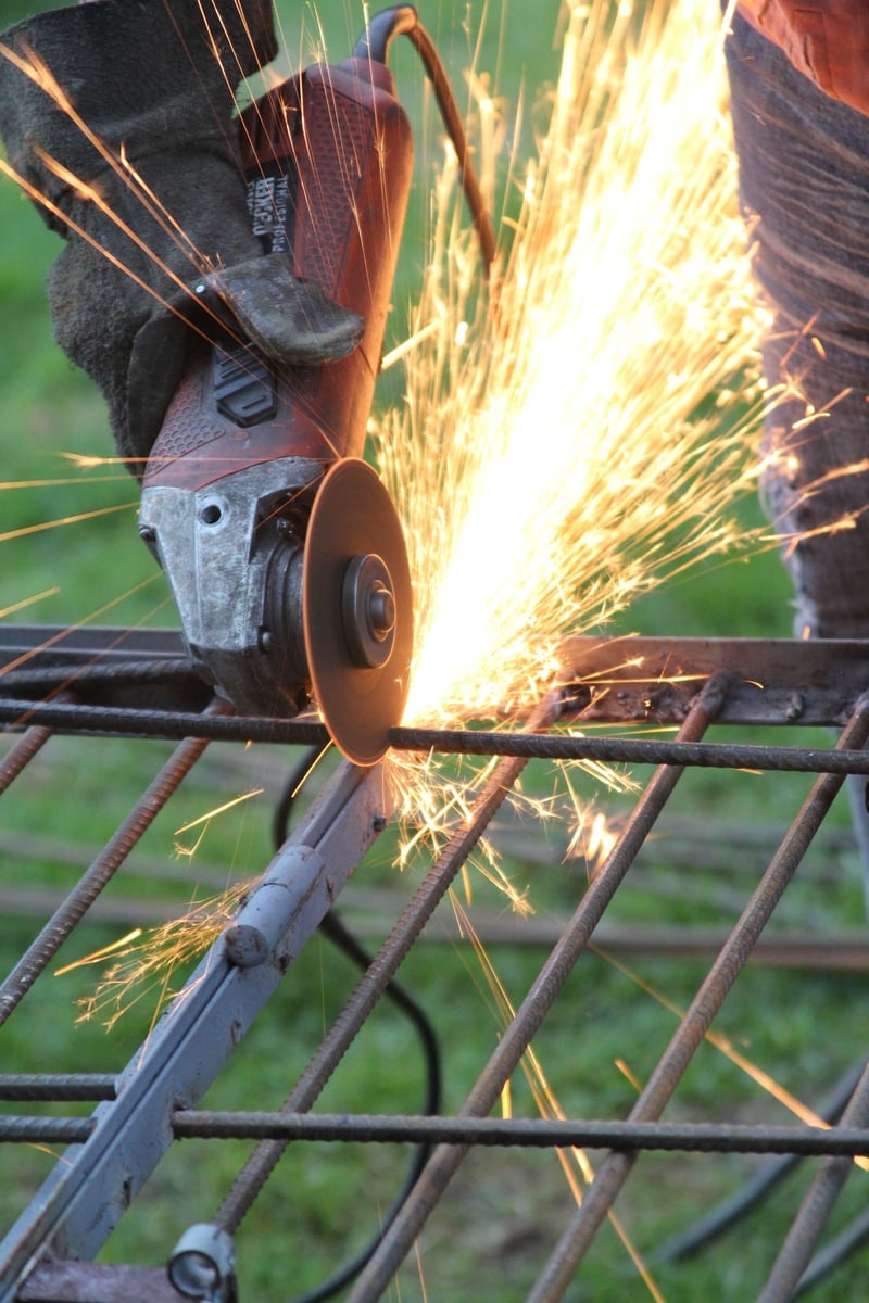Angle grinder cutting steel mesh — sparks flying at the yard